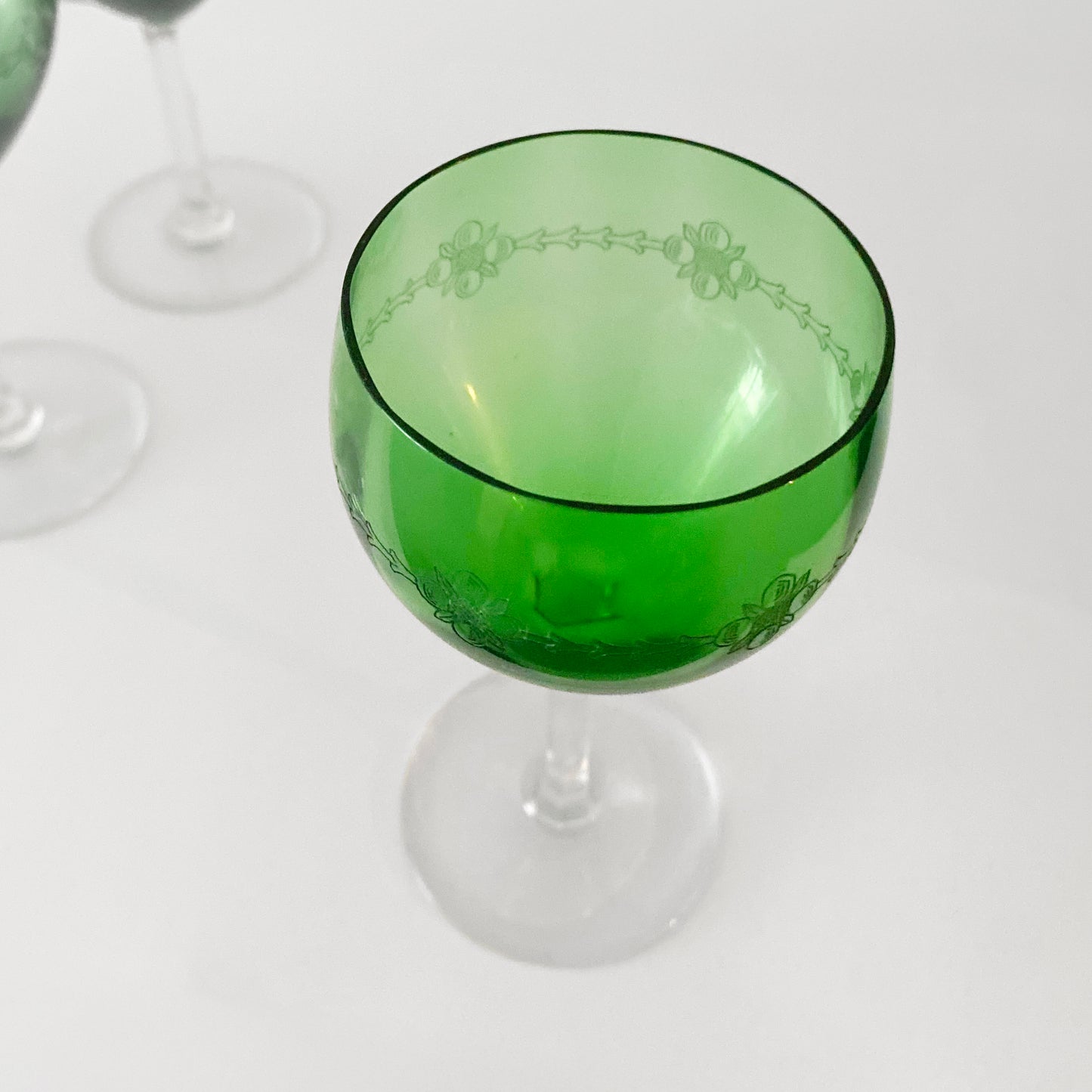 Green wine glass with floral patterns on a white background