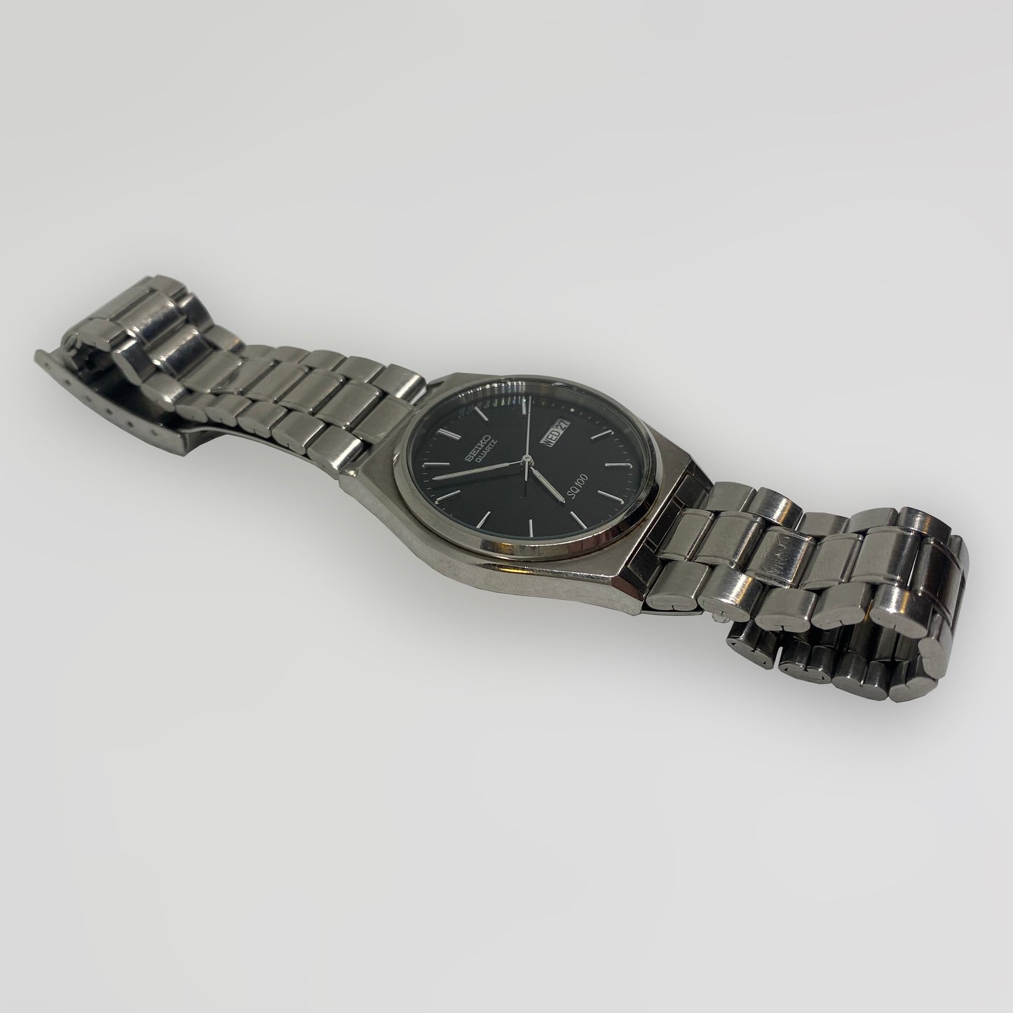 Silver watch with a black face on a white background