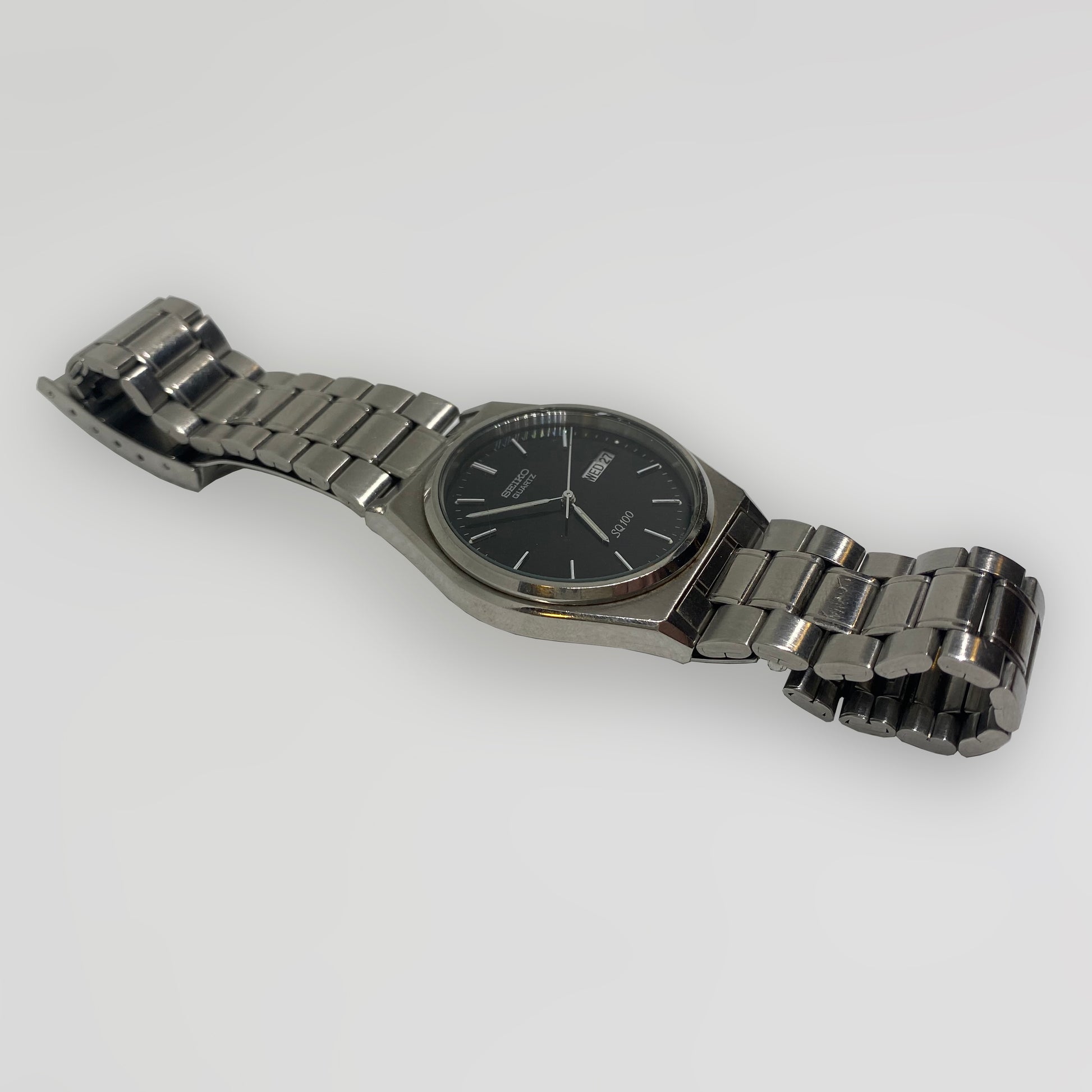 Silver watch with a black face on a white background