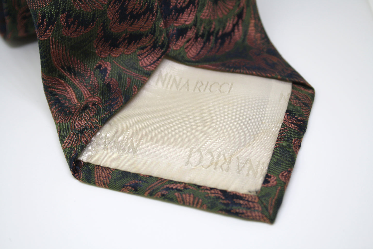 Nina Ricci tie with bird pattern on a white background