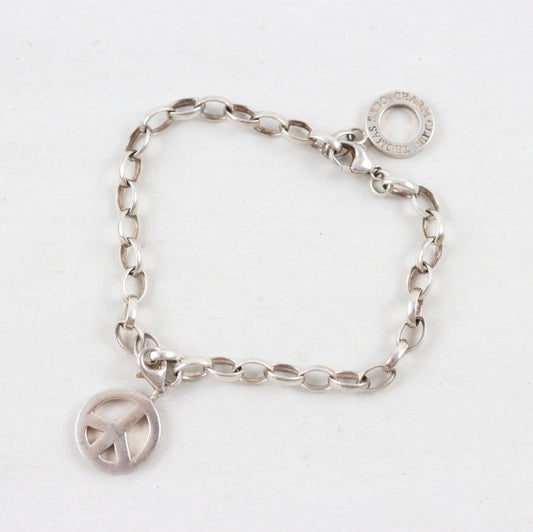 Silver bracelet with peace sign charm on a white background