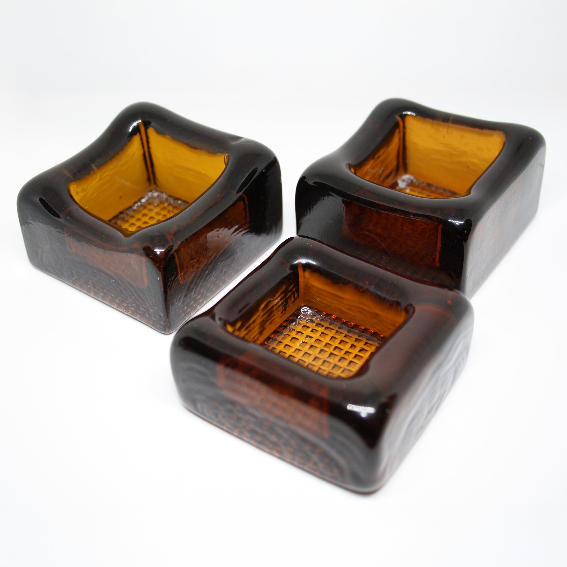 Three amber glass cubes on a white background