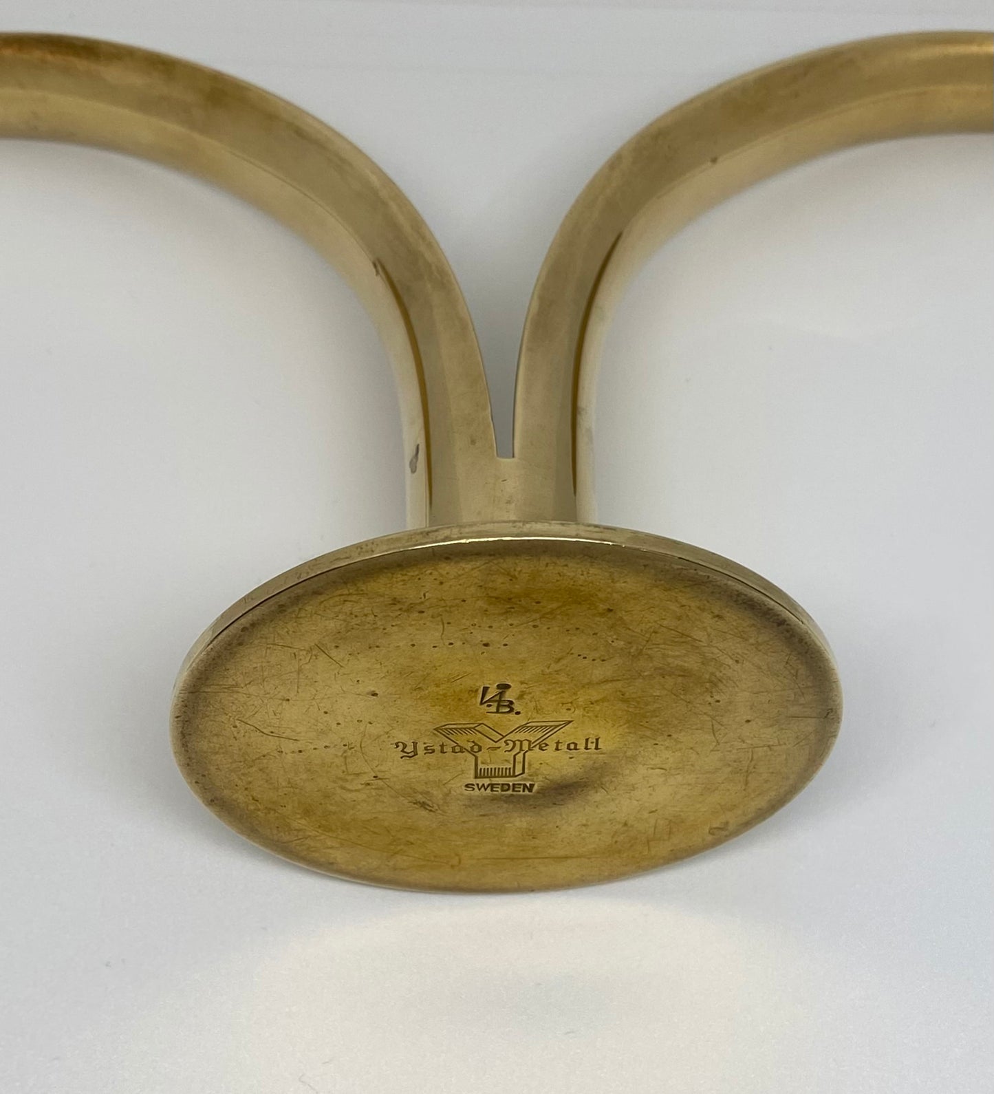 Brass candle holder with engraved text on a white background