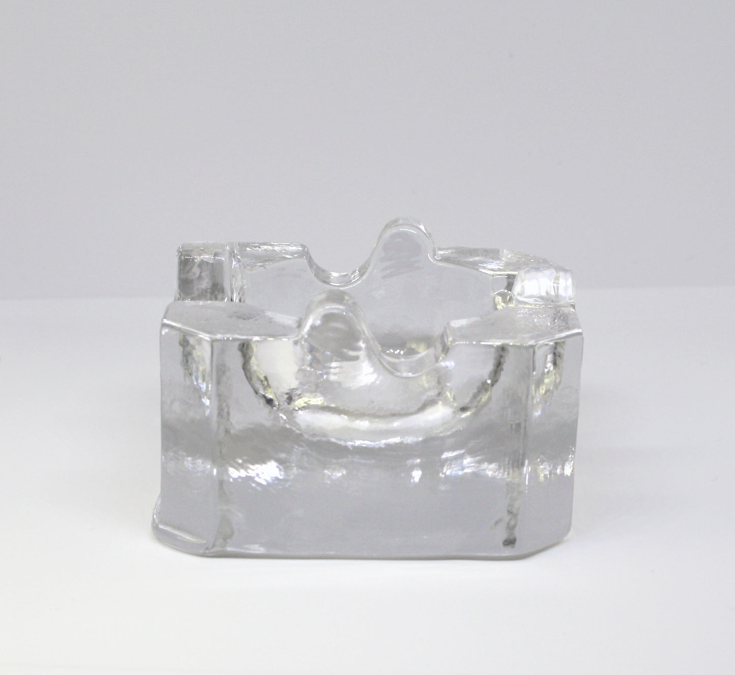 Clear glass ashtray on a white background