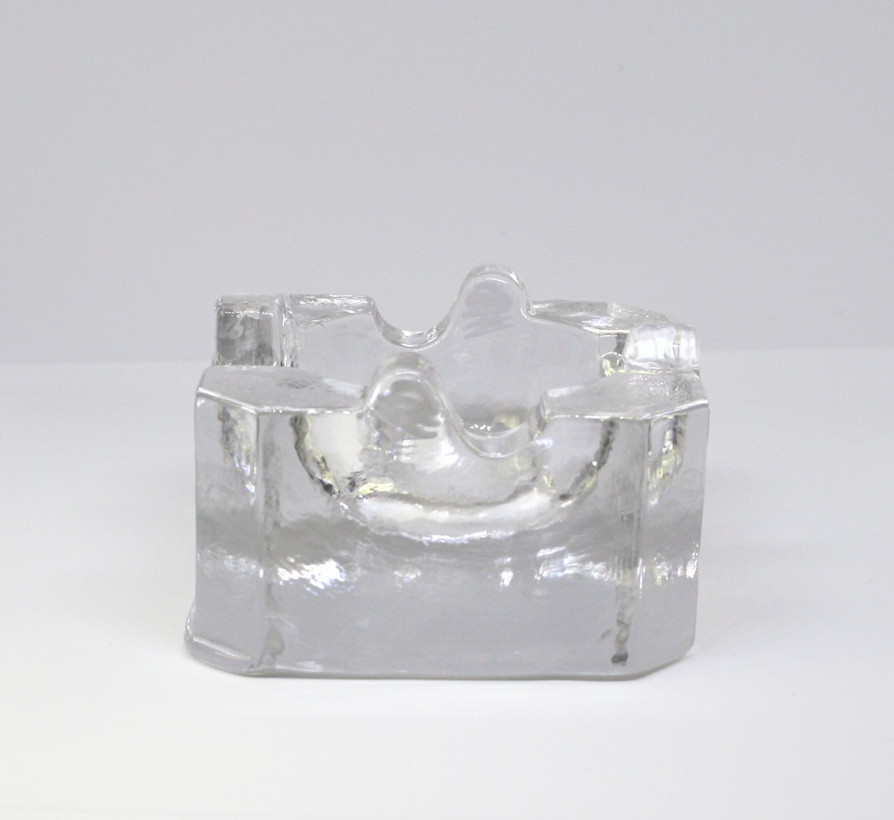 Clear glass ashtray on a white background