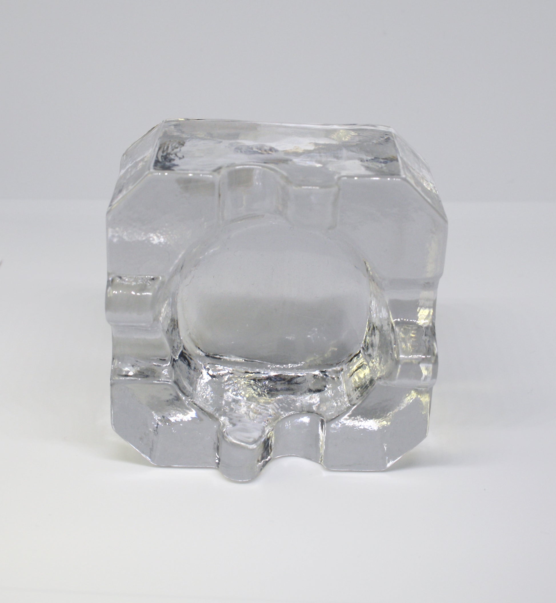 Clear glass ashtray on a white background