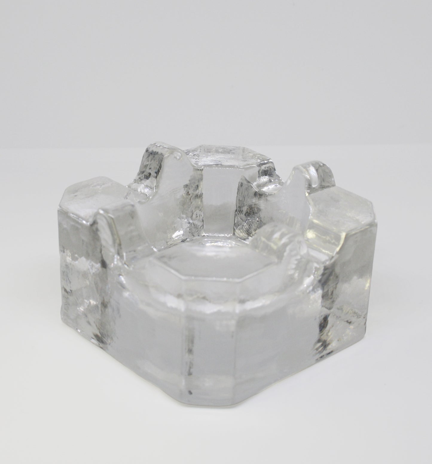 Clear glass ashtray on a white background