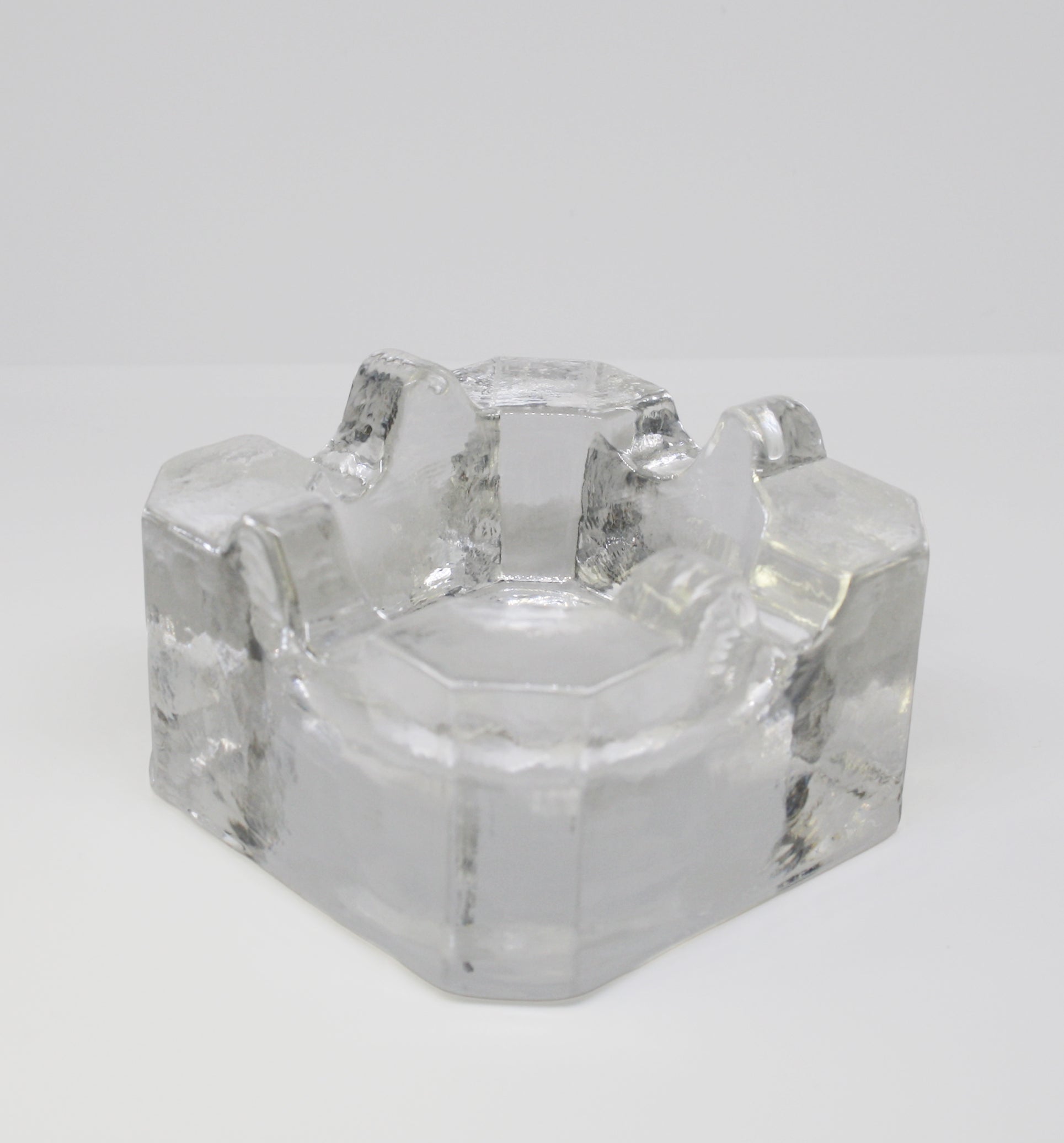 Clear glass ashtray on a white background