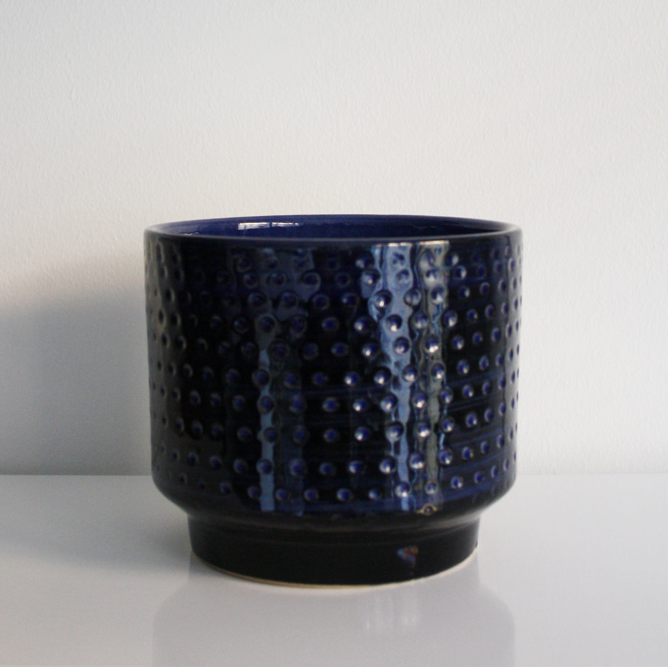 Blue textured ceramic pot on a white background